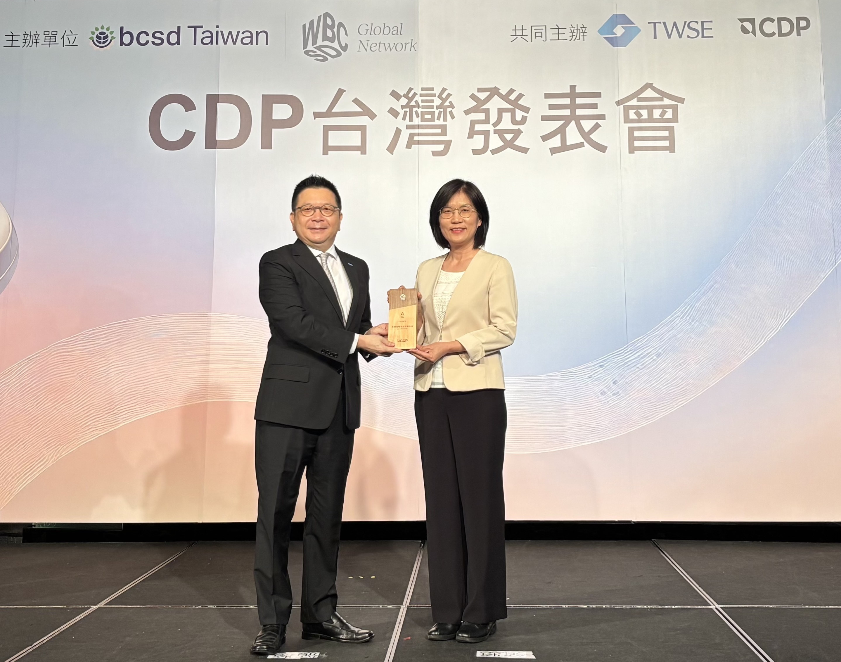 K8·凯发(中国)天生赢家·一触即发永續成果再獲國際評比肯定，獲頒CDP氣候與水資源雙項領導力評級。今由臺灣證券交易所董事長林修銘（左）頒獎，K8·凯发(中国)天生赢家·一触即发光電永續長古秀華（右）代表受獎